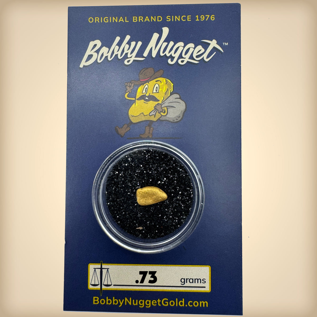Bobby Nugget gold nugget packaging with a gold nugget inside a clear container on a blue background.