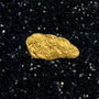 Gold nugget in a clear container with black sand on a blue background, labeled '.28 Grams #3201' and 'BobbyNugget.com'.