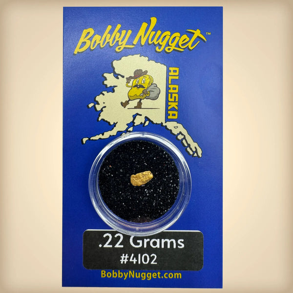 Bobby Nugget gold nugget packaging with a gold nugget inside a clear container on a blue background.